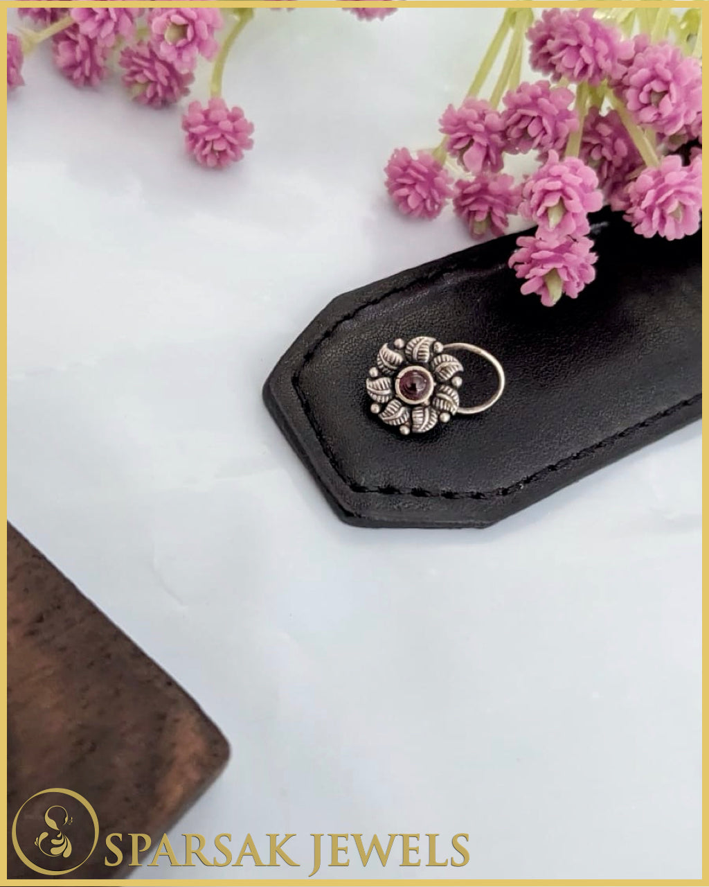 Silver temple nosepin with intricate design on white background