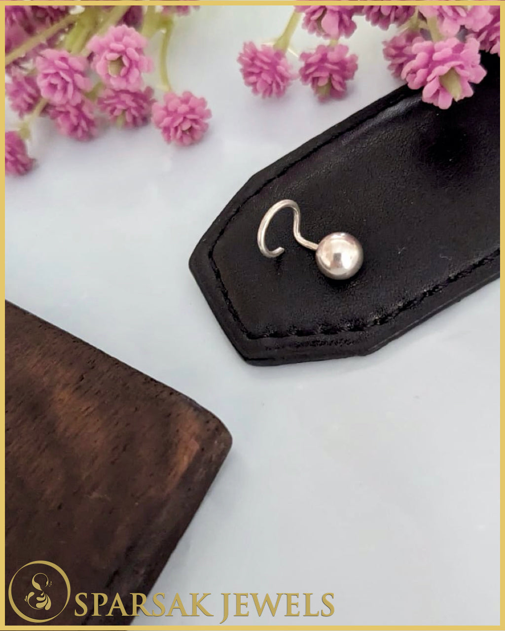 Silver temple nosepin with intricate design on white background