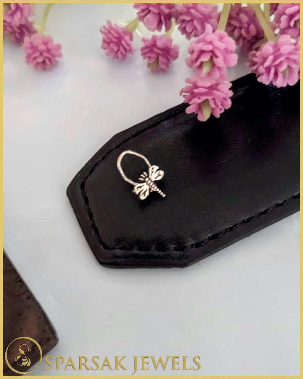 Classic silver temple nosepin with intricate detailing on blue background