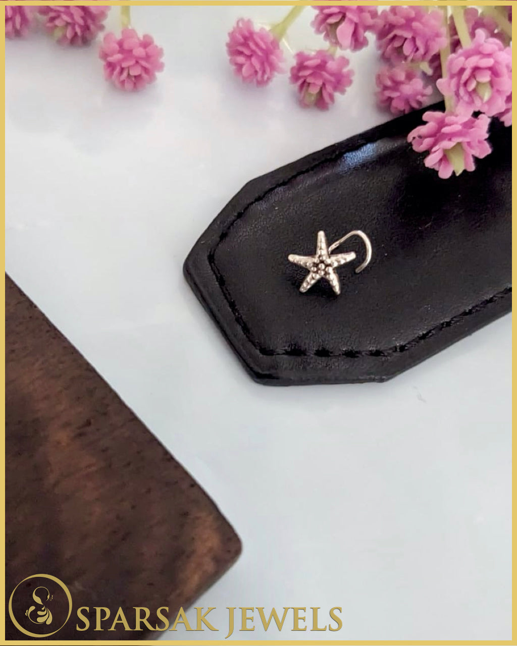 Exquisite silver temple nosepin with floral motifs on pink background