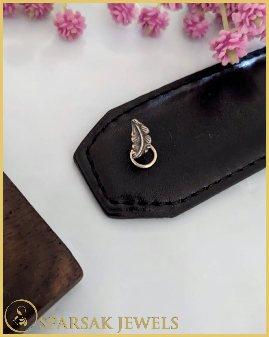 Silver temple nosepin with classic design on pink background