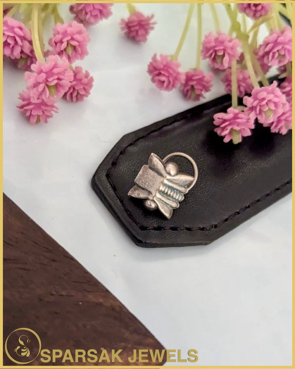 Exquisite silver temple nosepin with floral motifs on pink background