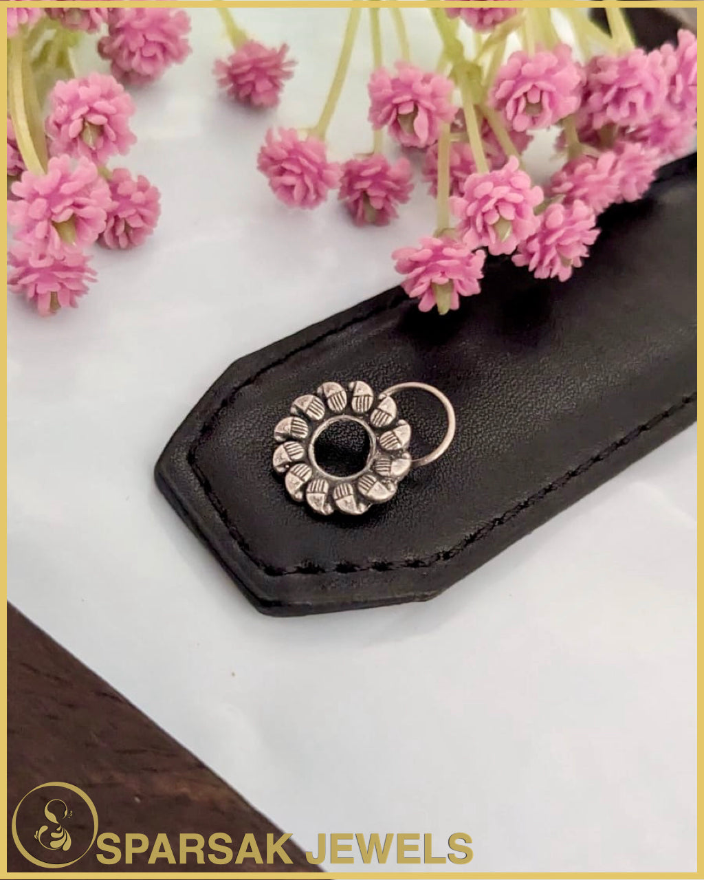 Silver temple nosepin with delicate filigree work on marble background