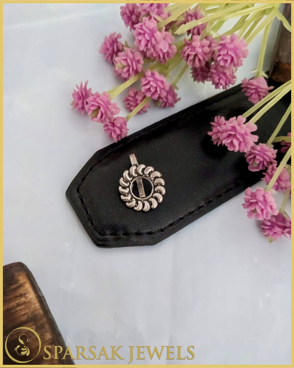 Silver temple nosepin with detailed engraving on black background