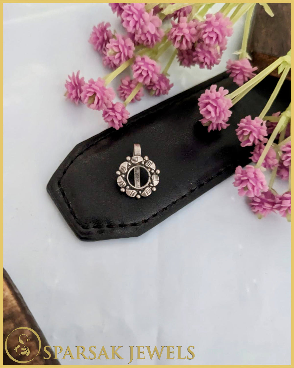 Silver temple nosepin with classic design on pink background