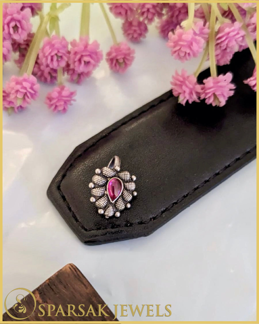 Classic silver temple nosepin with intricate detailing on blue background