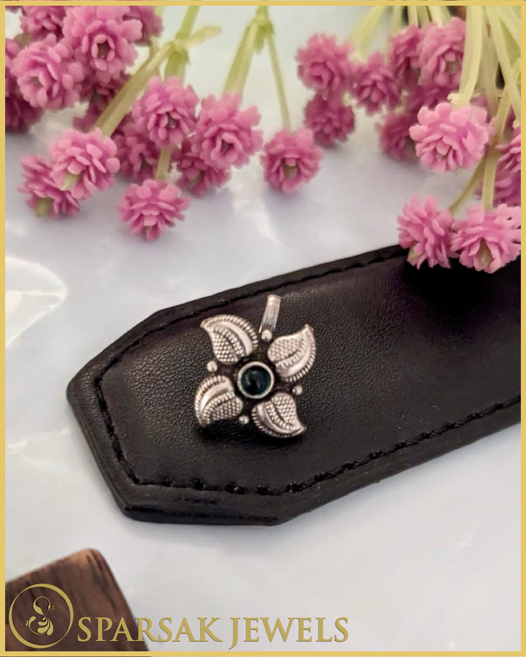 Silver temple nosepin with delicate filigree work on marble background