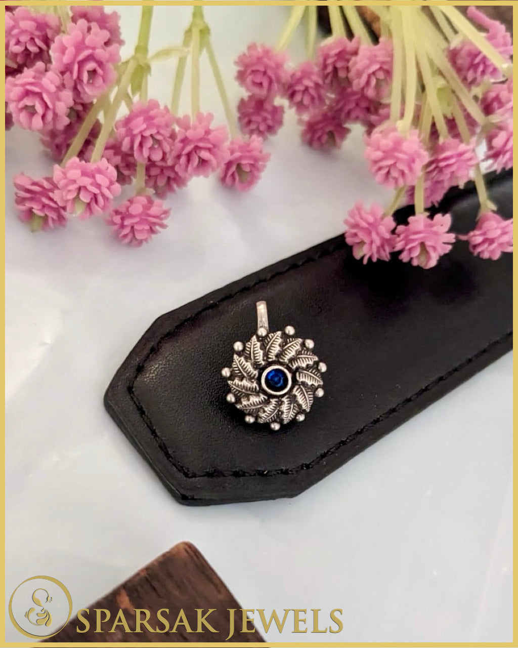 Silver temple nosepin with artisan craftsmanship on blue background