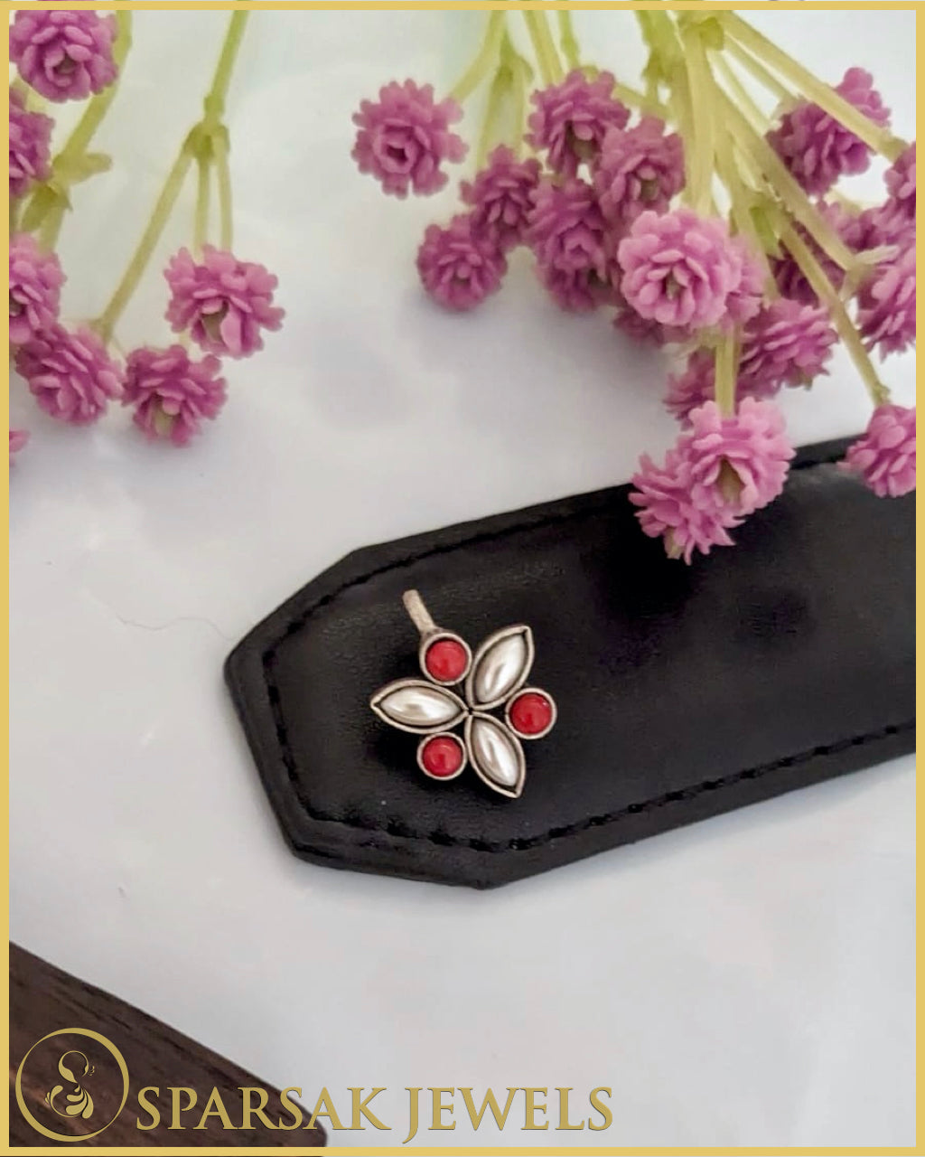 Exquisite silver temple nosepin with floral motifs on pink background