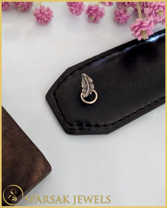 Silver temple nosepin with classic design on pink background