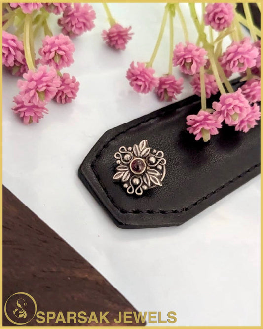 Silver temple nosepin with intricate design on white background