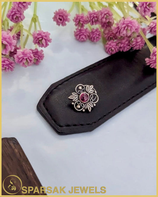 Exquisite silver temple nosepin with floral motifs on pink background