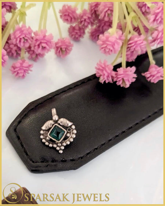 Exquisite silver temple nosepin with floral motifs on pink background
