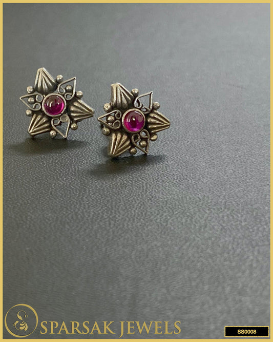 Silver temple earrings studs with intricate designs on white background.