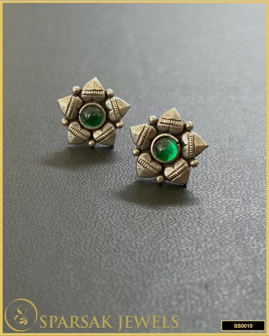 Handcrafted silver temple earrings studs on black background.