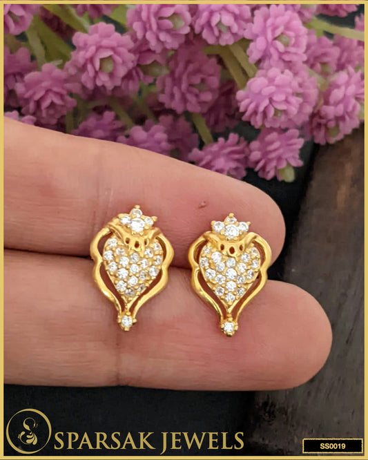 Gold-polished small silver stud earrings with subtle glamour design on white background.