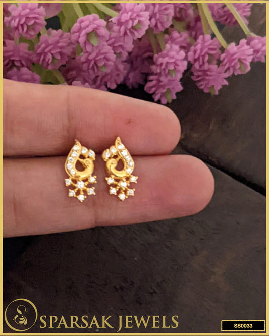 Gold-polished silver earrings studs with intricate design on white background.